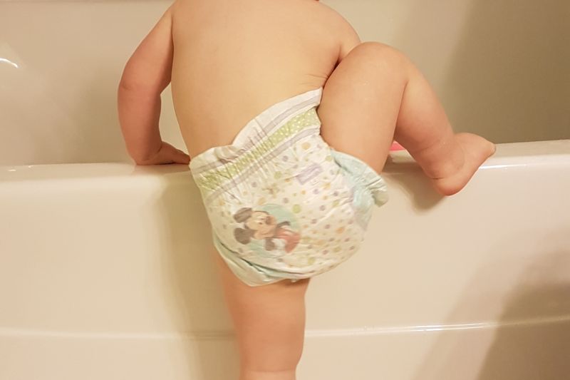 a child getting into the bath tub